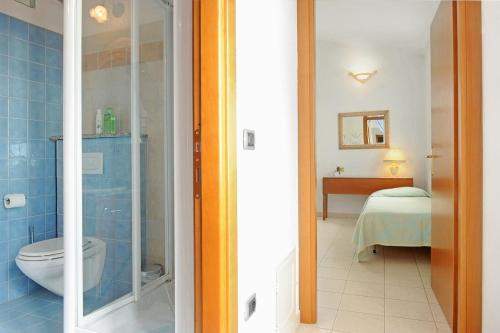 - une salle de bains avec toilettes et un lit dans une chambre dans l'établissement Il Giardino di Valentina, à Escolca