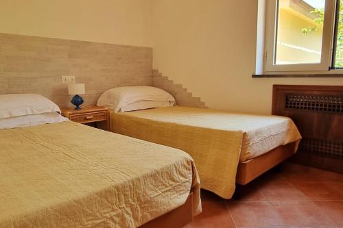 a bedroom with two beds and a window at Casa Vinaccia in Massa Lubrense