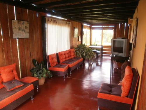 a room with couches and a tv in a room at Hotel Alto de los Andaquies in San Agustín