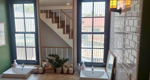 a bathroom with two sinks and a staircase with windows at Flow Garden Residence in Chiang Mai