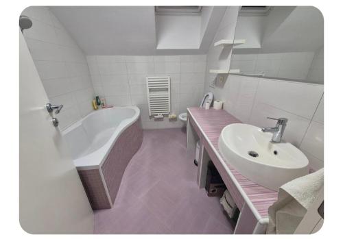 a white bathroom with a sink and a tub and a sink at Apartma pri lovcu in Trzin
