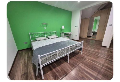 a green bedroom with a bed and a green wall at Apartma pri lovcu in Trzin