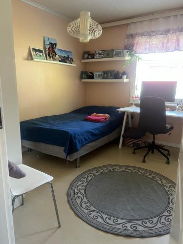 a bedroom with a bed and a desk and a chair at Spacious detached house in Mäntsälä