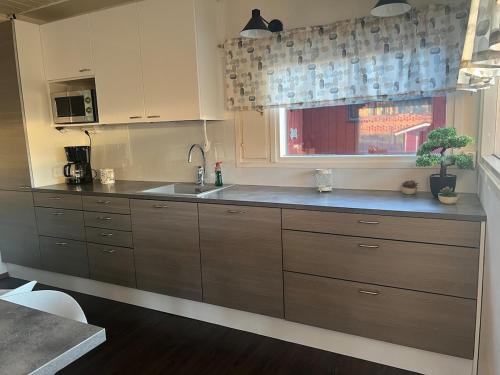 a kitchen with wooden cabinets and a sink and a window at Spacious detached house in Mäntsälä