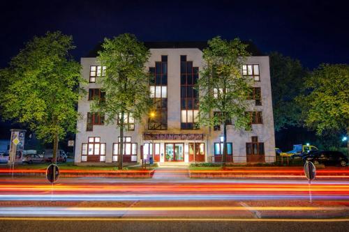a building at night with streaks of lights in front at Hotel Alina in Wiesbaden