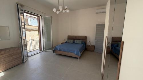 a bedroom with a bed and a large window at Le Cupole in Marsala