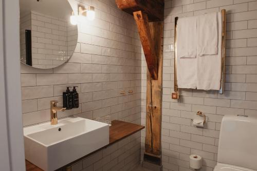 a white bathroom with a sink and a mirror at Home Hotel Packhuset in Kalmar