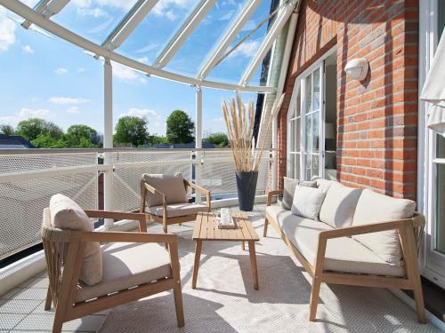 a conservatory with a couch and chairs on a balcony at Techts Strandhaus in Timmendorfer Strand