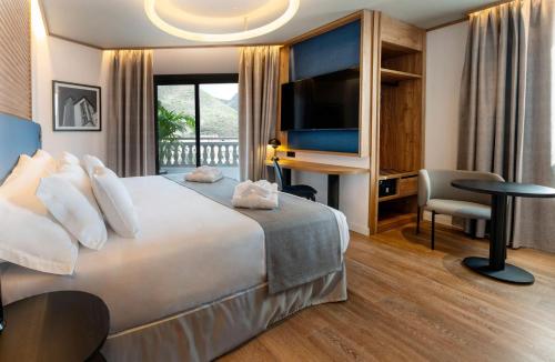 a hotel room with a large bed and a desk at Barceló Santa Cruz Contemporáneo in Santa Cruz de Tenerife