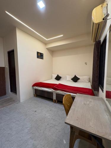 a room with a bed and a table in it at Hotel Shivay Deluxe in Nagpur