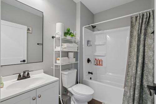 a white bathroom with a toilet and a sink at Valclyde Elevated Urban Haven in Minneapolis
