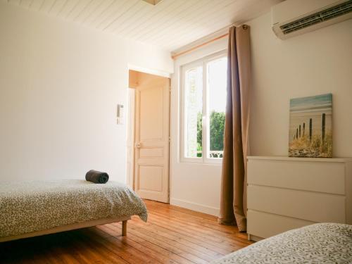 a bedroom with two beds and a window at L'ESCAPADE T3 avec terrasse privative in Lussac-les-Châteaux