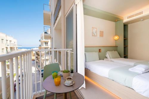 a hotel room with two beds and a balcony at Atlantis Lodge in Marsalforn