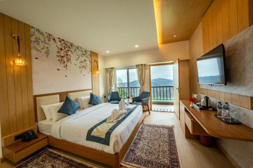 a hotel room with a bed and a television at Arkaya Mukteshwar by SuperGlitz Resorts Pvt Ltd in Mukteshwar