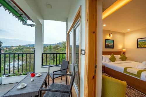 a bedroom with a balcony with a bed and a table at Arkaya Mukteshwar by SuperGlitz Resorts Pvt Ltd in Mukteshwar
