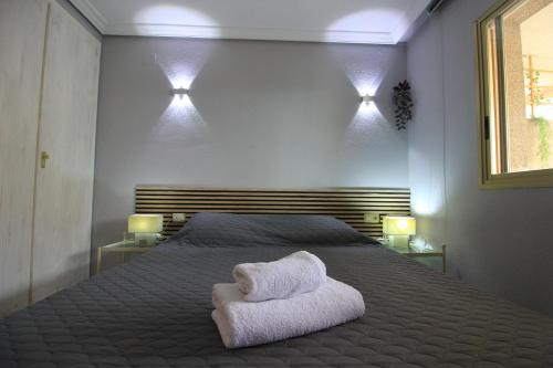 a bedroom with a bed with two towels on it at Apartment La Turquesa in La Pineda