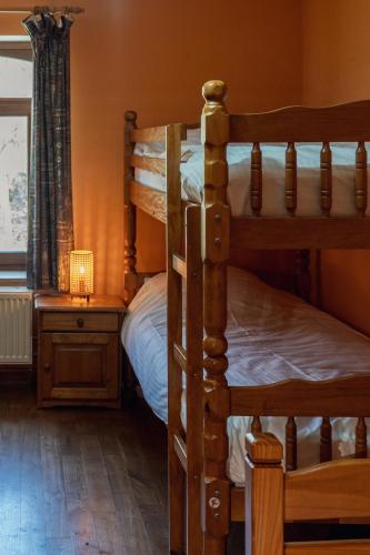 a bedroom with two bunk beds and a table with a lamp at Maison de la Turbine in Yvoir