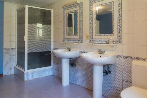 a bathroom with two sinks and a shower at Maison de la Turbine in Yvoir