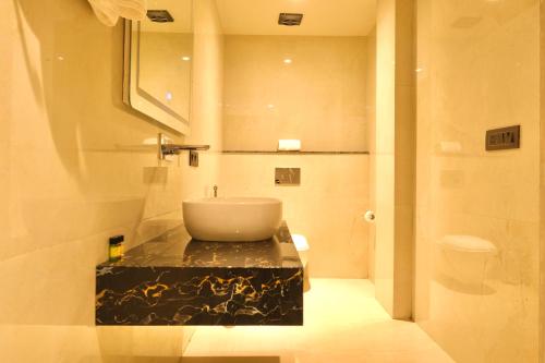 a bathroom with a sink on a black counter at Red Sapphire Royale in Morādābād