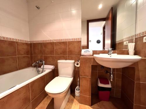 a bathroom with a toilet and a sink and a tub at AC Apartaments Cabirol Incles in Incles