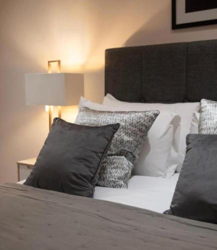 a bed with black and white pillows on it at Westminster two bed one bath sleeps 5 with Air-Con in London