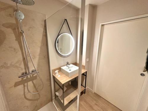 a bathroom with a sink and a mirror and a shower at Best Western Hotel de la plage Normandie in Asnelles