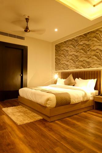 a bedroom with a large bed with a stone wall at Red Sapphire Royale in Morādābād