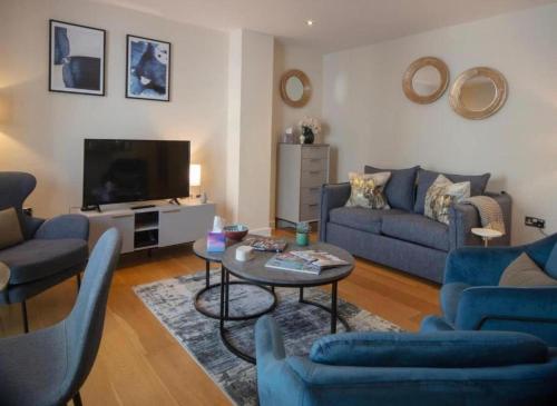 a living room with blue couches and a television at Westminster two bed one bath sleeps 5 with Air-Con in London