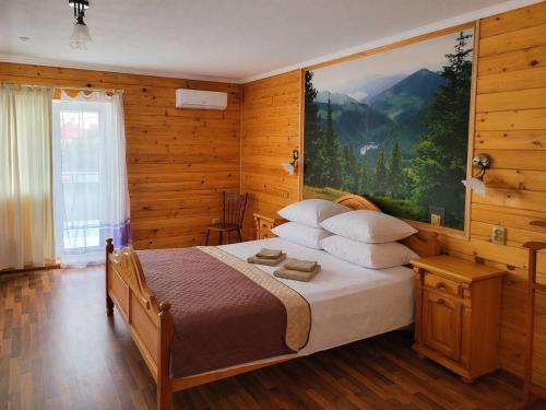 a bedroom with a bed with a large painting on the wall at SPA Villa Jasmin in Truskavets