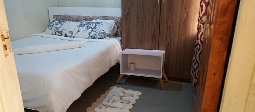a small room with a bed and a small table at Chaka homes 2 bedroom in Kiganjo
