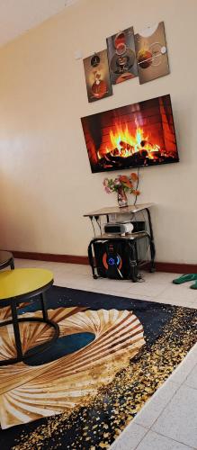 a living room with a fire in the wall at Chaka homes 2 bedroom in Kiganjo