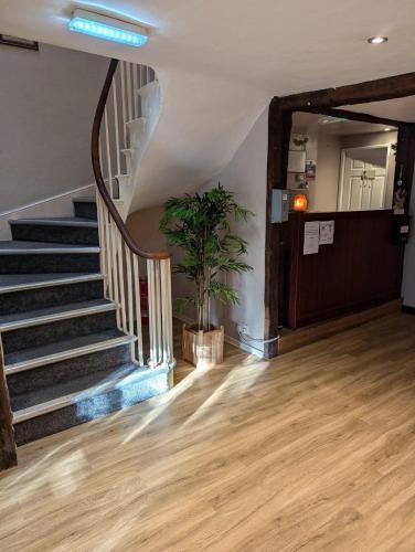 a staircase in a house with a potted plant at The Bell Hotel in Mildenhall