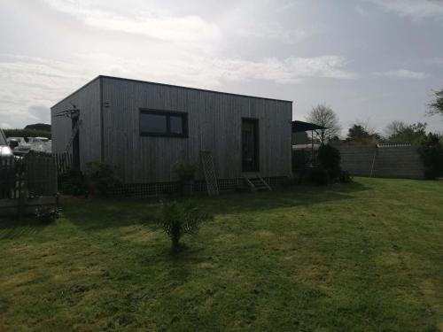 a small house in a yard with a fence at Cottage chaleureux in Locquirec