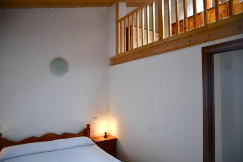 a bedroom with a bed with a light and a staircase at Villa Mare Monti in Maranola