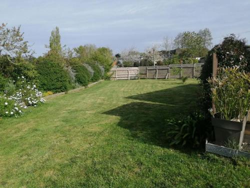 a yard with a fence and green grass at Cottage chaleureux in Locquirec