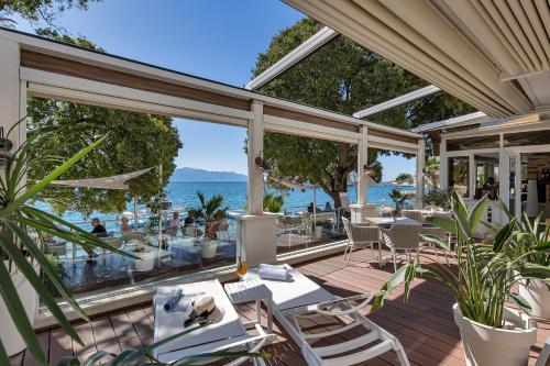 a patio with tables and chairs and the ocean at Boutique Hotel Marco Polo in Gradac