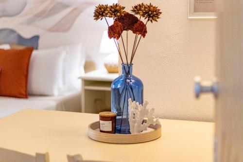 a blue vase with flowers in it on a table at Smeralda 15 in Porto Rotondo