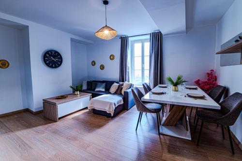 a living room with a couch and a table at TEMPLE JACQUESSON - Gare - Centre ville - WIFI RAPIDE et STREAMING - PARKING GRATUIT - CHECK IN 24H - CLIMATISATION - IDEAL PROS - cour privée - barbecue in Chalons en Champagne