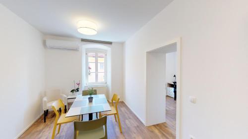 a dining room with a table and yellow chairs at Mestna Vila Krško in Krško