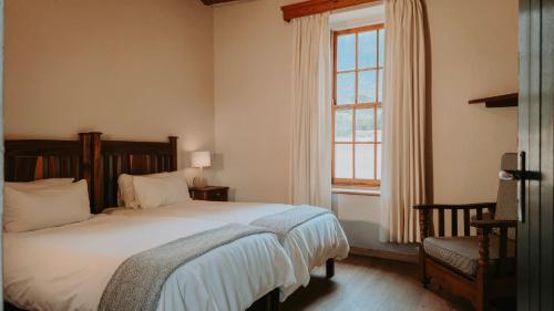 a bedroom with a large bed and a window at Oregon House in Riebeek-Wes