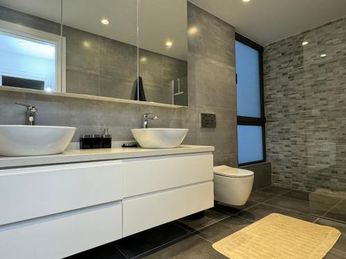 a bathroom with two sinks and a toilet at Esentepe Collection Nothern Cyprus Villas & Apartments with Sea View Nothern Cyprus in Pallouriotissa