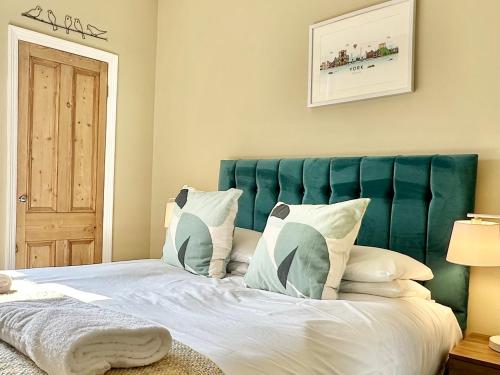 a bedroom with a large bed with a blue headboard at Montrose House in York