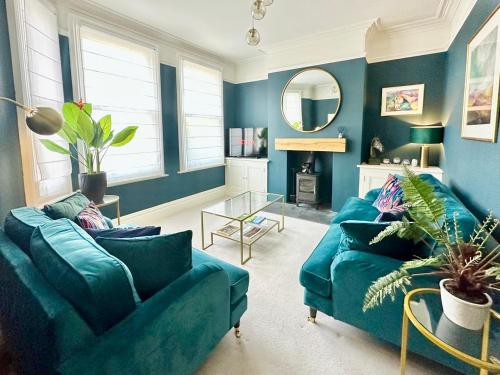 a living room with two blue couches and a mirror at Montrose House in York