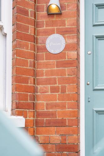 a brick wall with a door and a sign on it at Montrose House in York