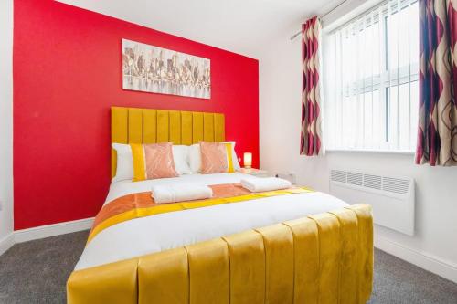 a bedroom with a yellow bed with a red wall at NEW! Stylish 5-Bed Apartment in Stockton-on-tees by Stay With Us, Perfect for Contractors & Large Groups, FREE Parking! in Thornaby on Tees