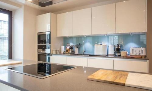 a kitchen with white cabinets and a counter top at Westminster 2 bed 2 bath apartment with Air-Con in London