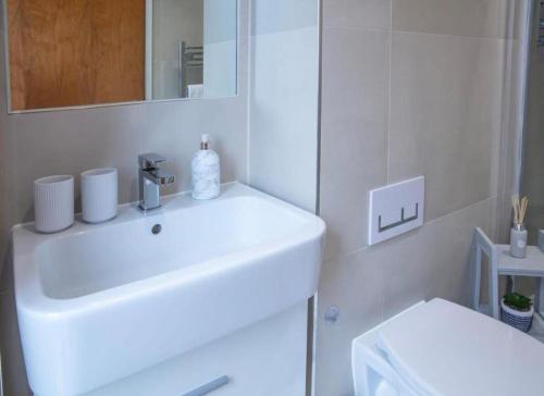 a white bathroom with a sink and a toilet at Westminster 2 bed 2 bath apartment with Air-Con in London