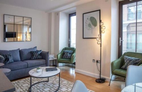 a living room with a blue couch and green chairs at Westminster 2 bed 2 bath apartment with Air-Con in London