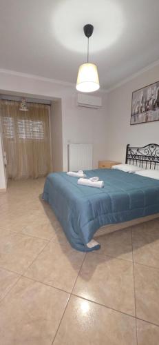 a bedroom with a large bed with a blue blanket at ARM OV Apartment in Alexandroupoli