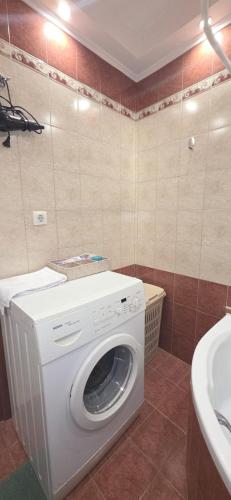 a washing machine in a bathroom next to a sink at ARM OV Apartment in Alexandroupoli